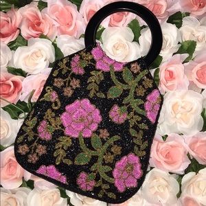 Beaded black handbag with pink and green flowers.